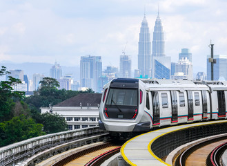 Malaysia Mass Rapid Transit (MRT) train with a background of Kuala Lumpur cityscape. People commute...