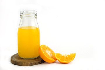 Fresh orange juice above wood coaster, with raw, sliced orange fruit – isolated on white background