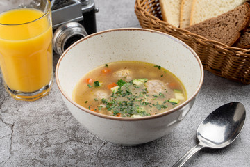 Comfort food: hot meatball soup with vegetables close up