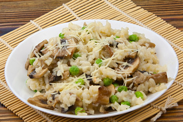 Tasty appetizing risotto on  white plate on  wooden background