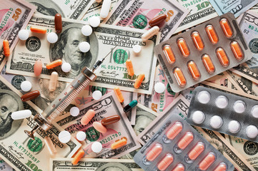 Syringe and medical pills on united states dollar currency money background