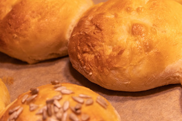 Home made bread rolls or buns for breakfast fresh on a paper on a table, selected focus, narrow...
