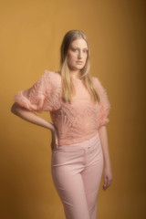Obraz premium Vintage 1960s fashion woman in pink sweater and pants.