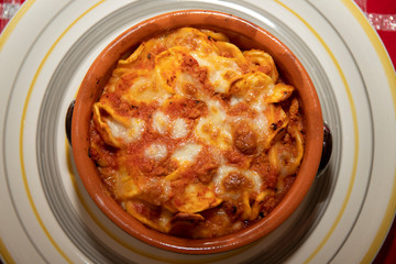 Baked pasta. Baked orecchiette with bolognese sauce (ragù alla bolognese) and mozzarella in terracotta dish. Italian cuisine. Apulian pasta.