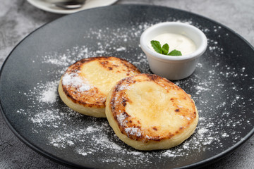 Traditional Russian cuisine: cottage cheese patties with sour cream