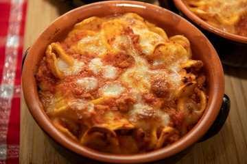 Baked pasta. Baked orecchiette with bolognese sauce (ragù alla bolognese) and mozzarella in terracotta dish. Italian cuisine. Apulian pasta.