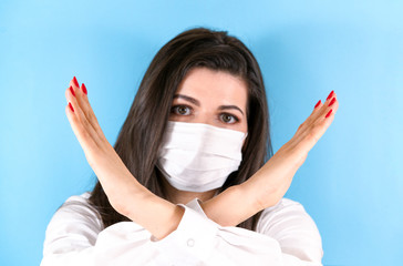 woman, wearing a protective medical mask , shows a stop gesture with crossed arms, air pollution....