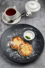 Traditional Russian cuisine: cottage cheese patties with sour cream