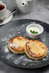 Traditional Russian cuisine: cottage cheese patties with sour cream