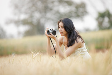 young tourist using camera to shoot barley rice farm
