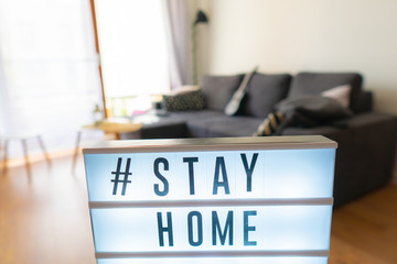 Coronavirus home sign lightbox with text hashtag #STAYHOME glowing in light. COVID-19 banner to...
