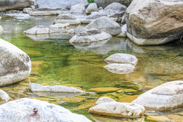 Fototapeta na wymiar Close-up of crystal clear water with rocks at a natural river at Sardinia, Italy