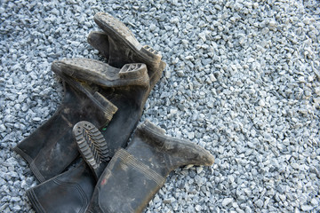 soiled black boots placed on the stone floor