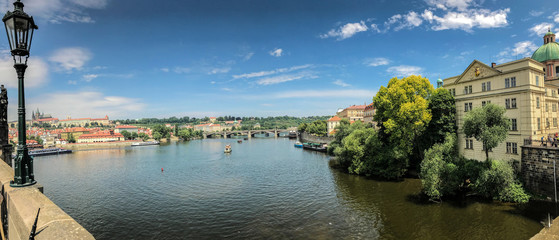 Panorama showing an amazing water view over Prague with blue sky and blue water