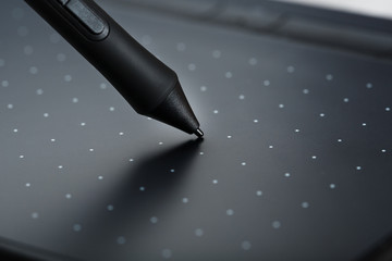 Pen and graphic tablet close-up on a gray textural background. Gadget for working as a designer,...