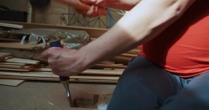Pregnant woman using a chisel in the loft