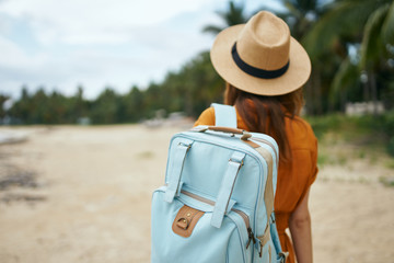woman with suitcase on the beach