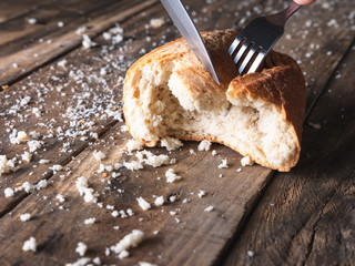 piece of bread being cut with fork and knife