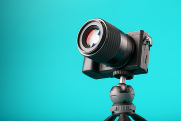 Professional camera on a tripod, on a blue background. Record videos and photos for your blog or report.