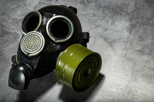 Gas Mask On A Black Stone Background With A Green Filter Cartridge. Post-apocalyptic Concept.