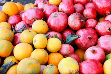 natural orange oranges and red pomegranates on the market