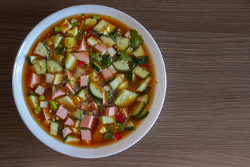 Traditional cold russian soup okroshka with sausage, vegetables and kvass. Free space for text. Top view