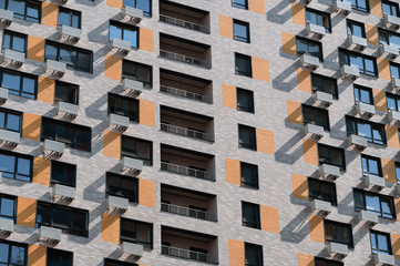 gray-orange brick modern skyscraper with balconies and windows. new buildings for mortgages. sleeping areas of the city