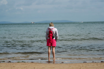 Young woman looking out at the ocean. 