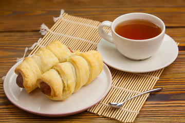 Crispy pies sausages on a plate on  wooden background