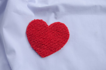 Fresh red heart on white clothes floor