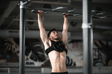 Obraz na płótnie Canvas Man during workout in the gym Concept: power, strength, healthy lifestyle, sport. Powerful attractive muscular Man CrossFit trainer do battle workout with ropes at the gym. Young man exercising using