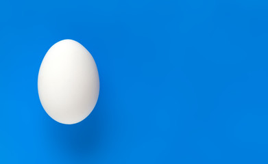Easter egg on colorful blue background with space for text