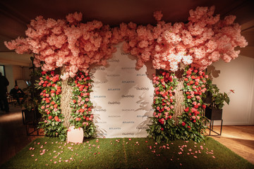 festive decorated arch with pink flowers