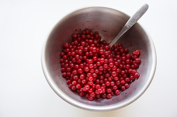 Red berries in a metal dish.