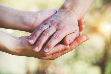 helping hands, rehabilitation, hospice and nursing home care, service, elderly people care concept, young female hands holding wrinkled hand of senior woman