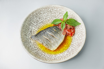 fish steak with vegetable and basil served on table