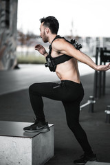 Fototapeta premium Man during workout in the gym Concept: power, strength, healthy lifestyle, sport. Powerful attractive muscular Man CrossFit trainer do battle workout with ropes at the gym. Young man exercising using