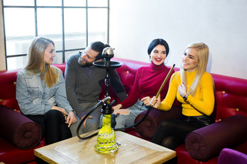 Friends smoke hookah and have fun, laugh