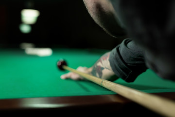 Rear view of man aiming the billiard ball with cue