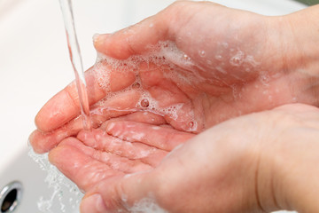 woman washes hands under the tap close up