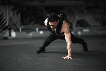 Fototapeta premium Man during workout in the gym Concept: power, strength, healthy lifestyle, sport. Powerful attractive muscular Man CrossFit trainer do battle workout with ropes at the gym. Young man exercising using