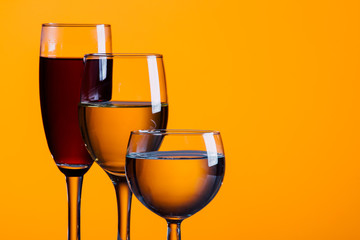 Wine glasses against orange background. 