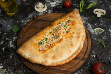 Italian cuisine. Big calzone on a wooden board