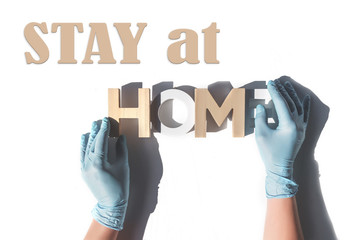Stay home. Hands in medical gloves keep the word home. Coronavirus and protection against covid 19....