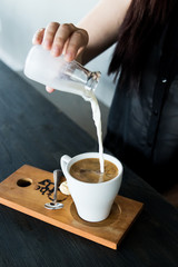 Pouring milk into coffee mug