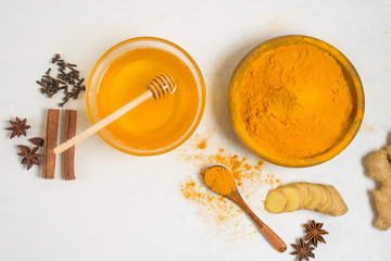 Obraz na płótnie Canvas ingredients for Indian traditional Golden milk with turmeric, ginger, spices, honey. healing effect of the drink. antiviral therapeutic antioxidant