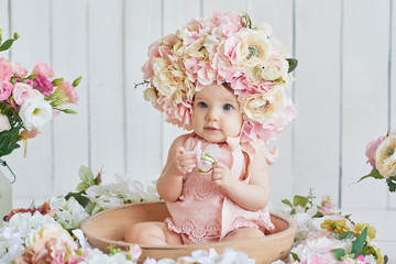 Sweet funny baby in hat with flowers. Easter greeting card, copyspace for your text. Poster for...