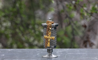  metal urn with ashes of dead person on funeral,  Sad grieving moment at end of life. 