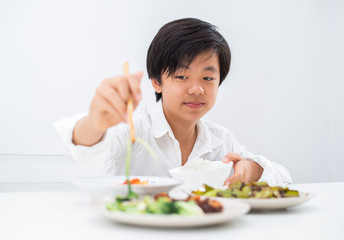 Obraz na płótnie Canvas Handsome Asian boy eating with chopsticks