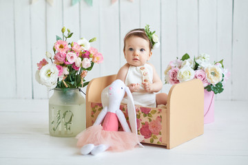 Sweet funny baby in hat with flowers. Easter greeting card, copyspace for your text. Poster for Easter holiday. Congratulations on Mother's Day. Cute baby girl 6 months wearing flower hat.